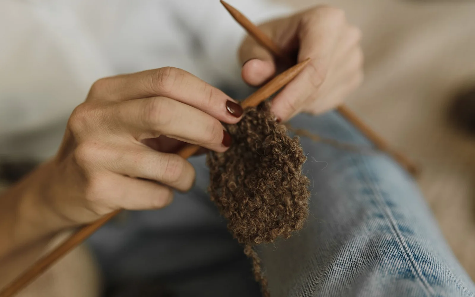 Hands darning a cashmere sleeve in the Care Studio