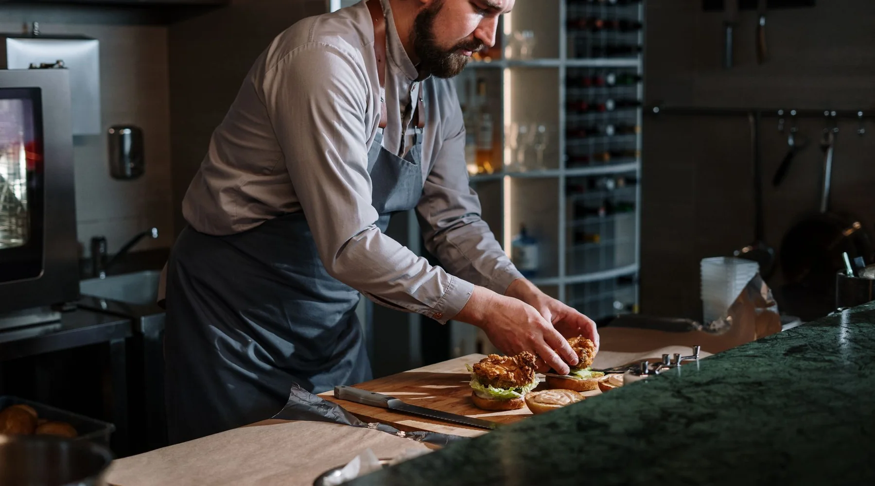 A cook building burgers in the Emberjack kitchen