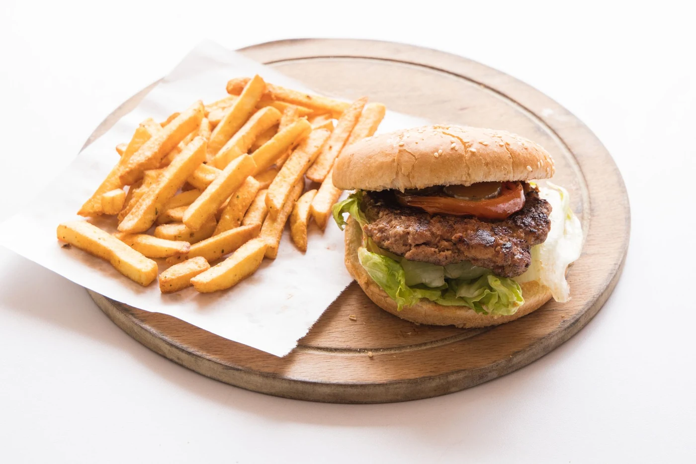 An Emberjack burger and fries on a wooden board
