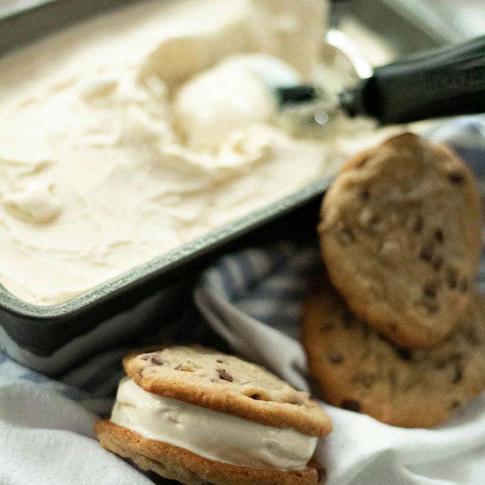 Ice cream sandwich beside a tray of vanilla ice cream