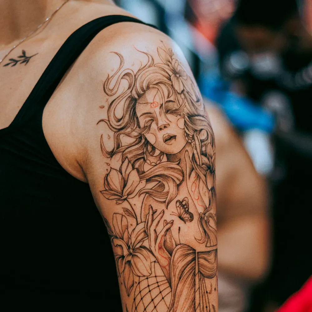 Woman in flowers, Fine-line tattoo on the Upper arm by Isha Menon