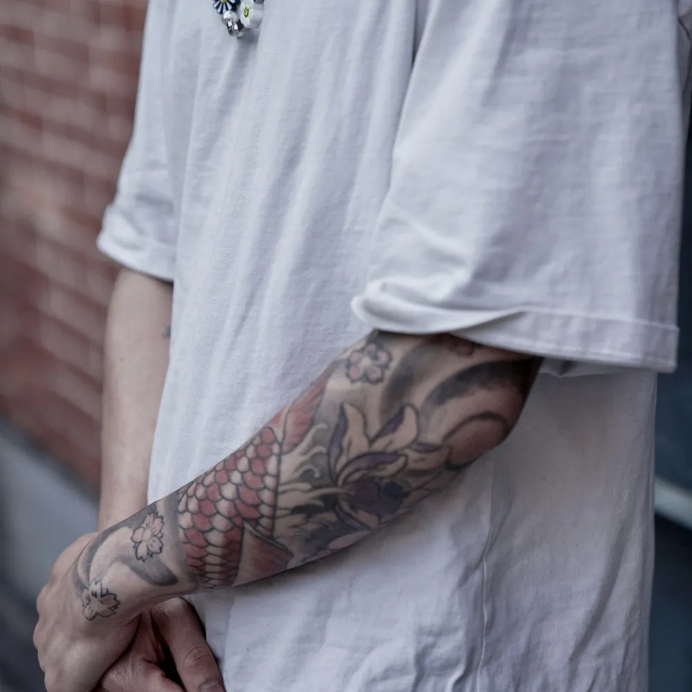 Koi sleeve, Japanese tattoo on the Full sleeve by Yuki Arai