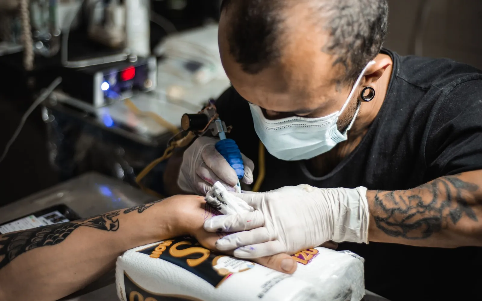 Artist tattooing a client's forearm at the Blackthorn studio
