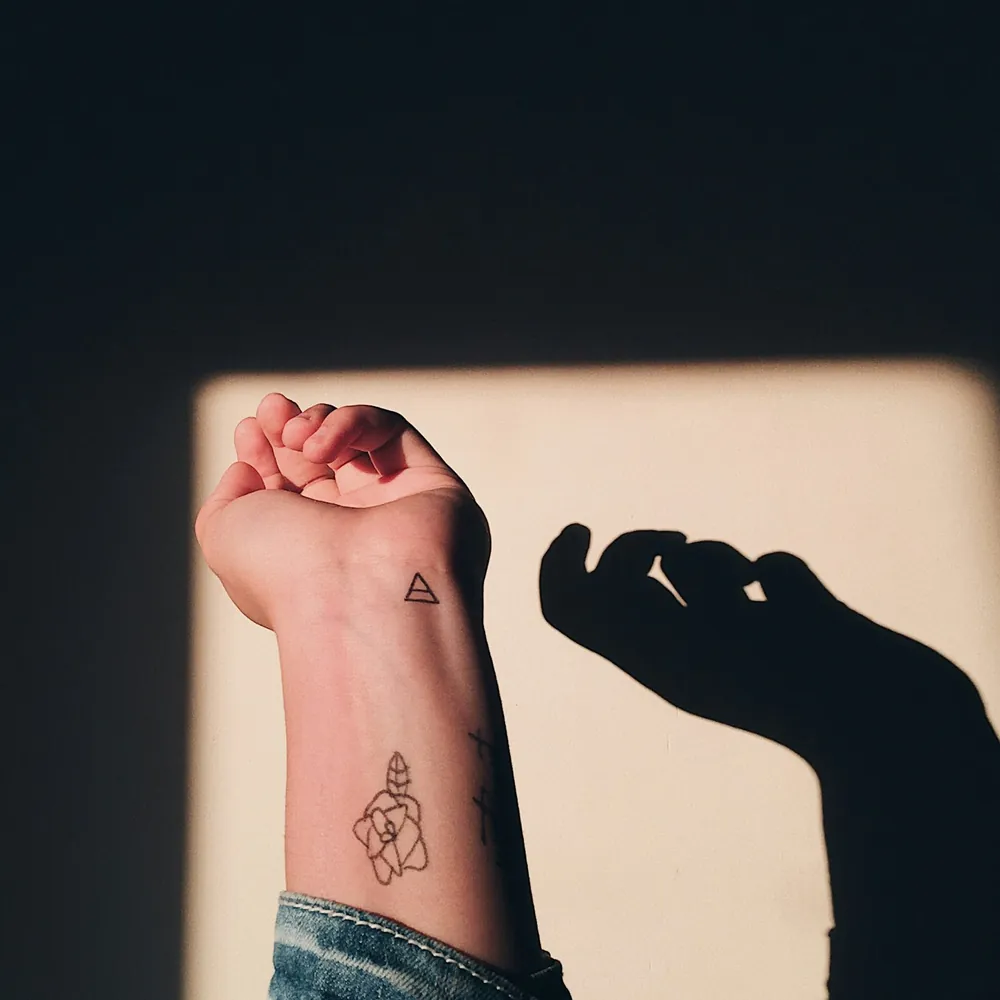 Triangle & flower, Fine-line tattoo on the Wrist by Mara D'Souza